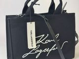 sac fourre-tout noir avec une inscription blanche et une étiquette sur le côté