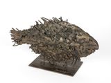 une photo d'une sculpture représentant un poisson posée sur un socle en bois