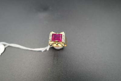 un gros plan d'une bague ornée d'une pierre rose sur un fond noir