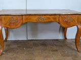 a wooden desk with a marble top on a tiled floor
