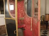 a red and gold carriage in a room with black and white checkered floor