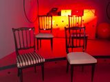 two chairs and a table in a room with a red light