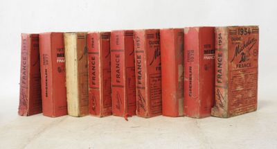 several old books are lined up in a row on a white surface