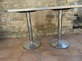 two tables that are sitting on the ground in front of a brick wall