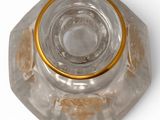a glass ashtray with a gold rim on a white surface