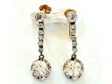 une paire de boucles d'oreilles en diamant et en or sur fond blanc