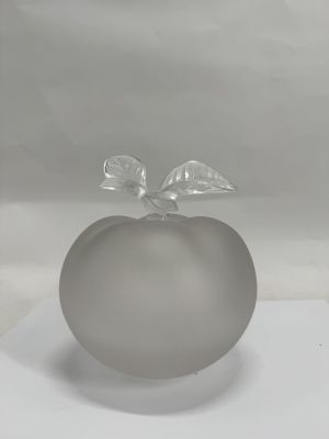 a glass apple with a leaf on top of it