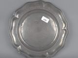 une assiette en argent ornée d'un motif floral sur le bord