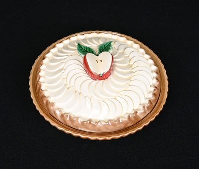un gâteau recouvert de glaçage blanc et surmonté d'une pomme rouge