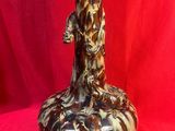 un vase marron et blanc posé sur un tissu rouge
