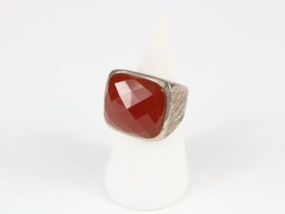 a close up of a ring with a red stone on it