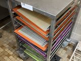 Plusieurs plateaux de nourriture sont posés sur un chariot métallique dans une cuisine