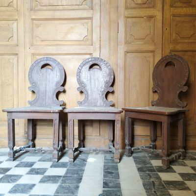 deux chaises en bois placées l'une à côté de l'autre sur un sol à carreaux
