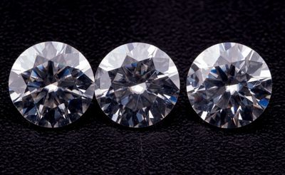 trois diamants ronds taille brillant sur fond noir