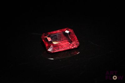 a close up of a red diamond on a black surface