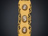 a gold broochle with two cameos of two men and a woman