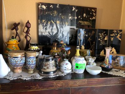 de nombreux vases et bols posés sur une commode dans une pièce
