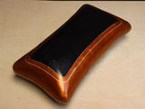 une mallette marron et noire posée sur une table en bois