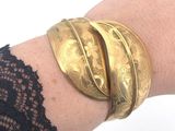 a close up of a woman ' s arm with a gold bracelet