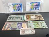 Plusieurs billets de banque différents sont exposés dans une vitrine transparente.