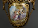 un grand vase orné d'une peinture, posé sur un socle
