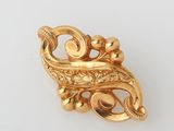 an image of a gold broochle on a white surface