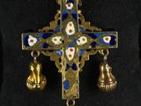 a cross with bells and bells hanging from it