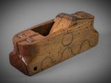 an old wooden plane with a piece of wood sticking out of it