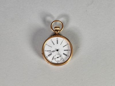 une petite montre de poche en or avec des chiffres romains