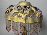 a lamp that is on a stand with beads