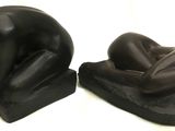 deux statues noires représentant un homme et une femme allongés sur le dos