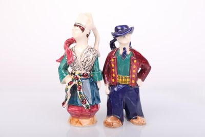 two figurines of a man and a woman standing next to each other