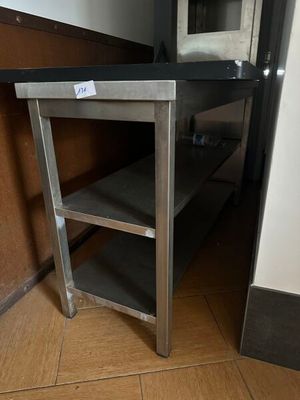 une table en métal avec un plateau en verre dans une cuisine