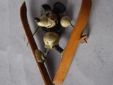a small toy mouse skiing on a wooden board