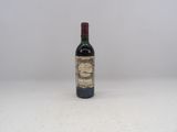 une vieille bouteille de vin posée sur une table blanche