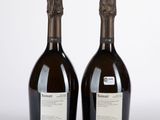 deux bouteilles de vin posées l'une à côté de l'autre sur une surface blanche