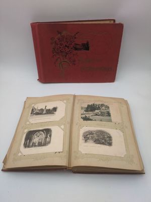 un livre ouvert posé sur une table blanche, à côté d'une boîte rouge