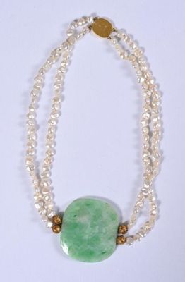 collier de perles avec une pierre verte et des perles sur fond blanc