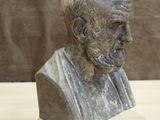 statue of a bust of a man with a beard sitting on a table