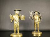 paire de figurines anciennes en laiton représentant un homme et une femme tenant des paniers