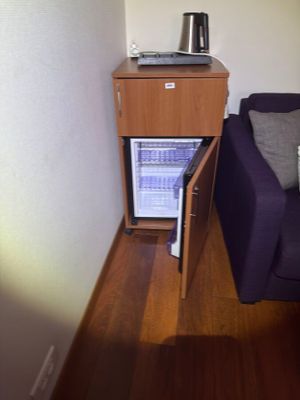 a blue couch and a small cabinet in the corner of a room