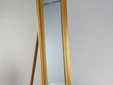 un miroir posé sur un pied dans une pièce