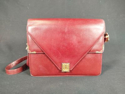 a red leather handbag with a gold clasp on the front
