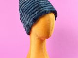 un gros plan sur la tête d'un mannequin coiffée d'un bonnet tricoté