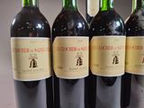 several bottles of wine are lined up on a table
