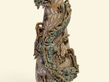 a vase with a dragon on it sitting on a stand
