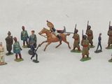 many figurines of different types of soldiers on a white surface