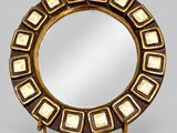 a close up of a mirror on a stand on a gray surface