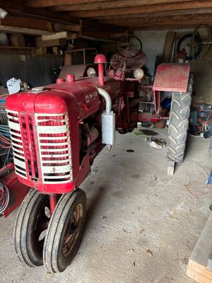 un tracteur rouge qui est garé dans un garage