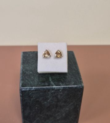 un gros plan sur une paire de boucles d'oreilles posées sur un bloc de marbre